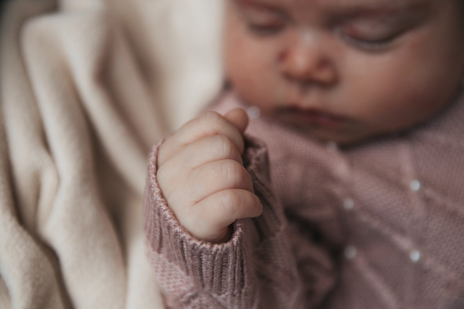 Close do rosto de um bebê com roupa bege