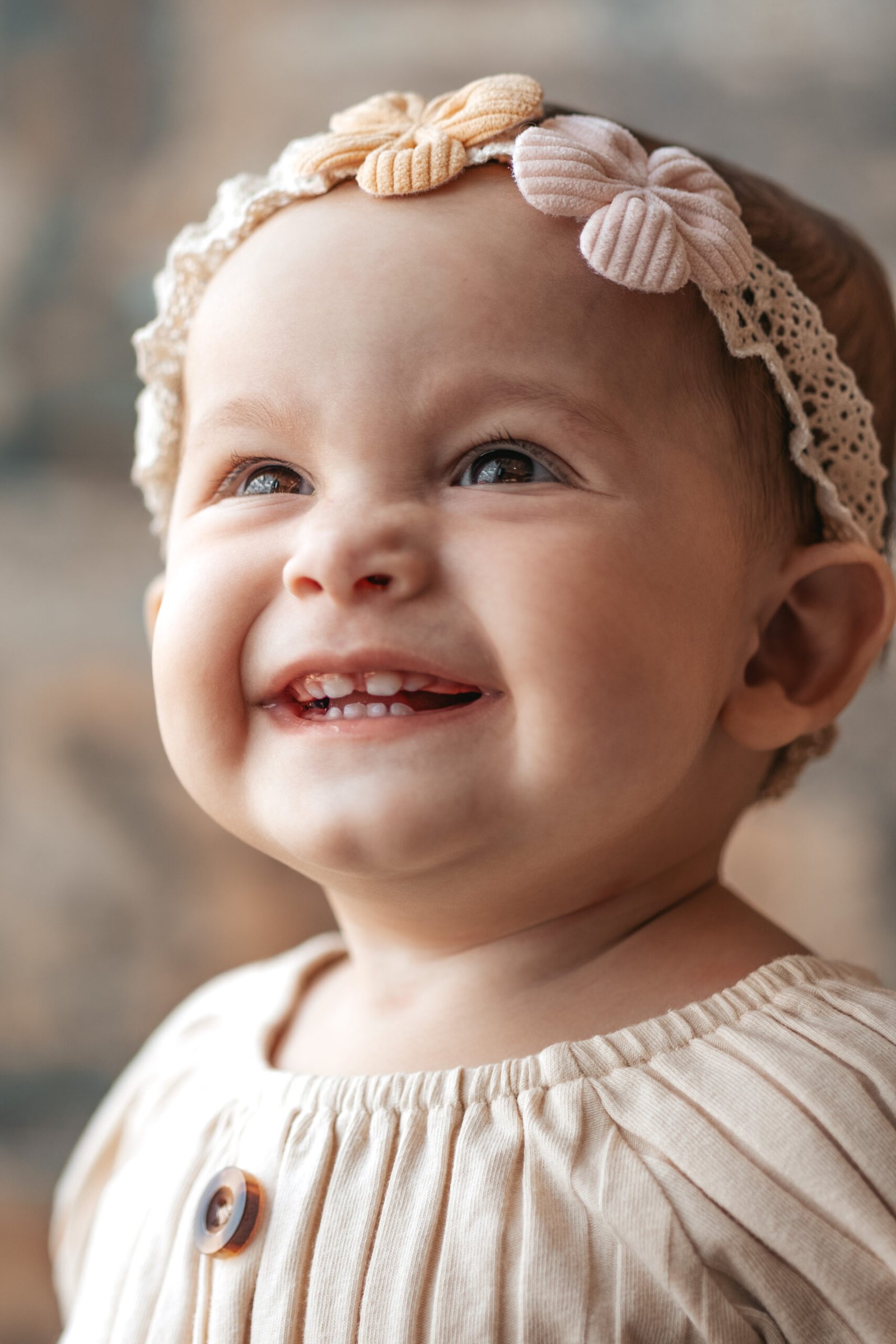 Bebê de roupa marrom com tiara floral