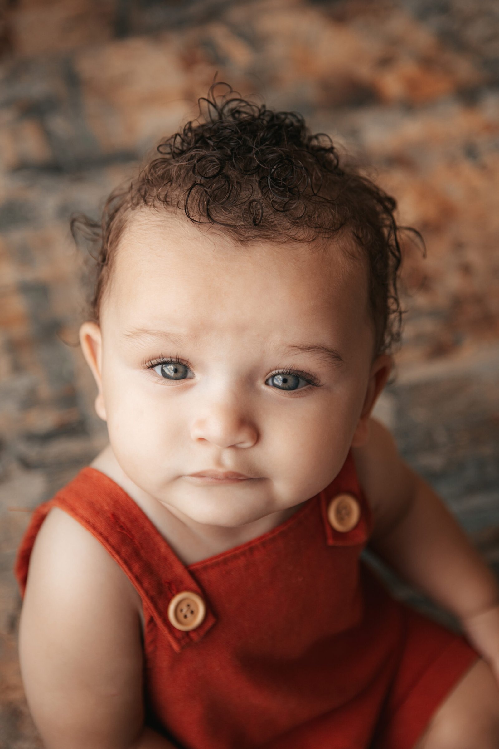 Close do rosto de um bebê com laço bege