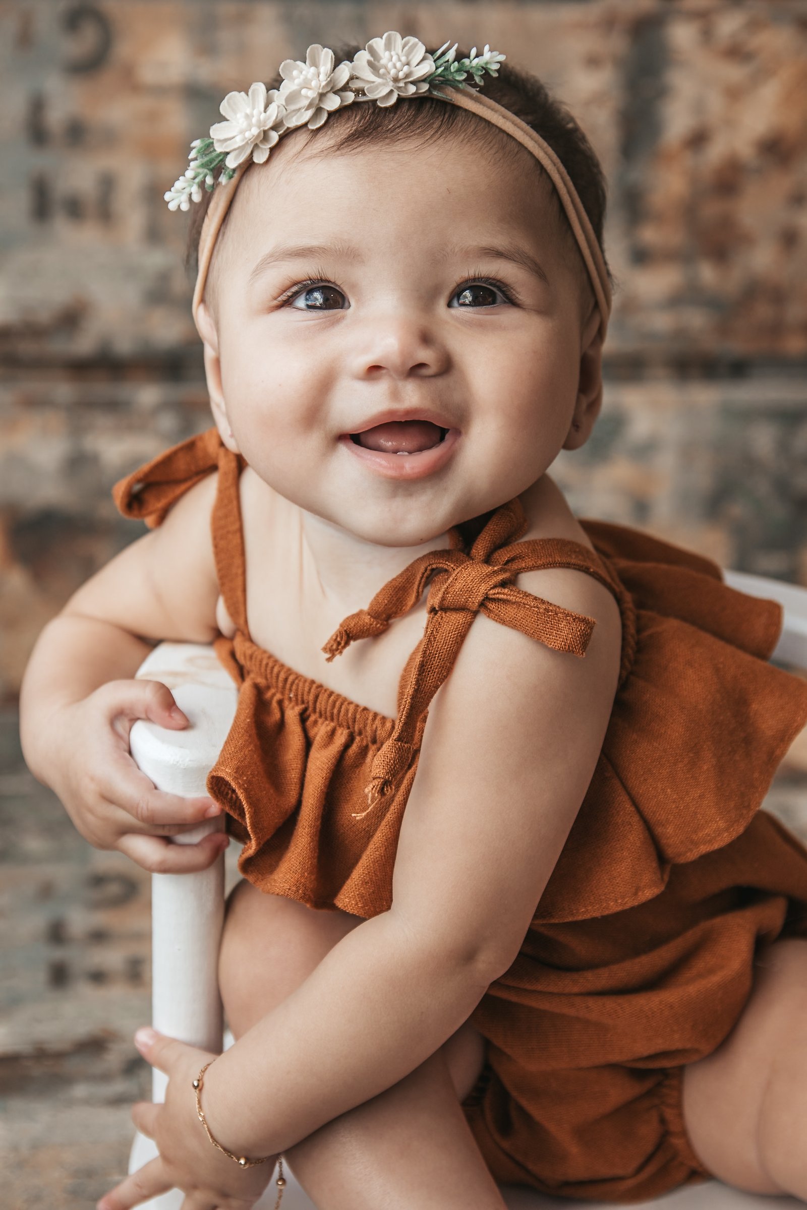 Bebê olhando para cima com tiara floral